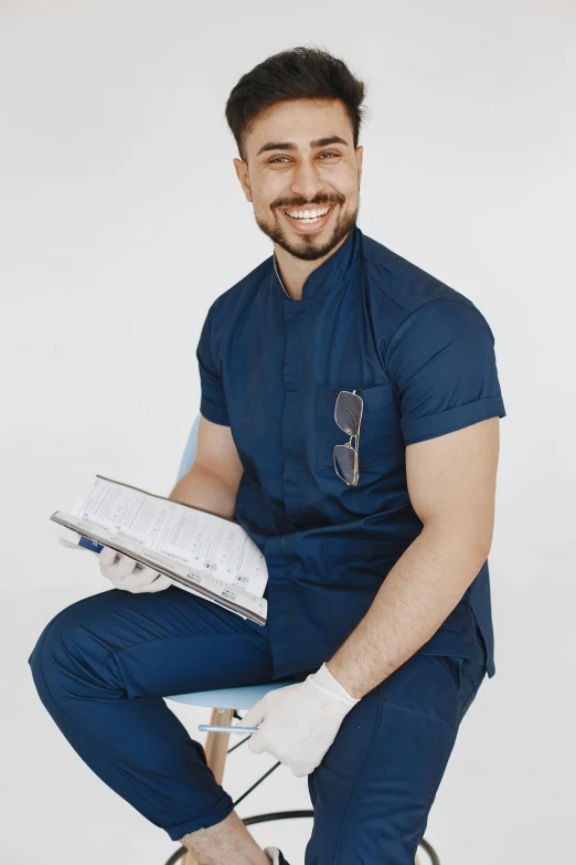 man with medical gown sitting in a chair