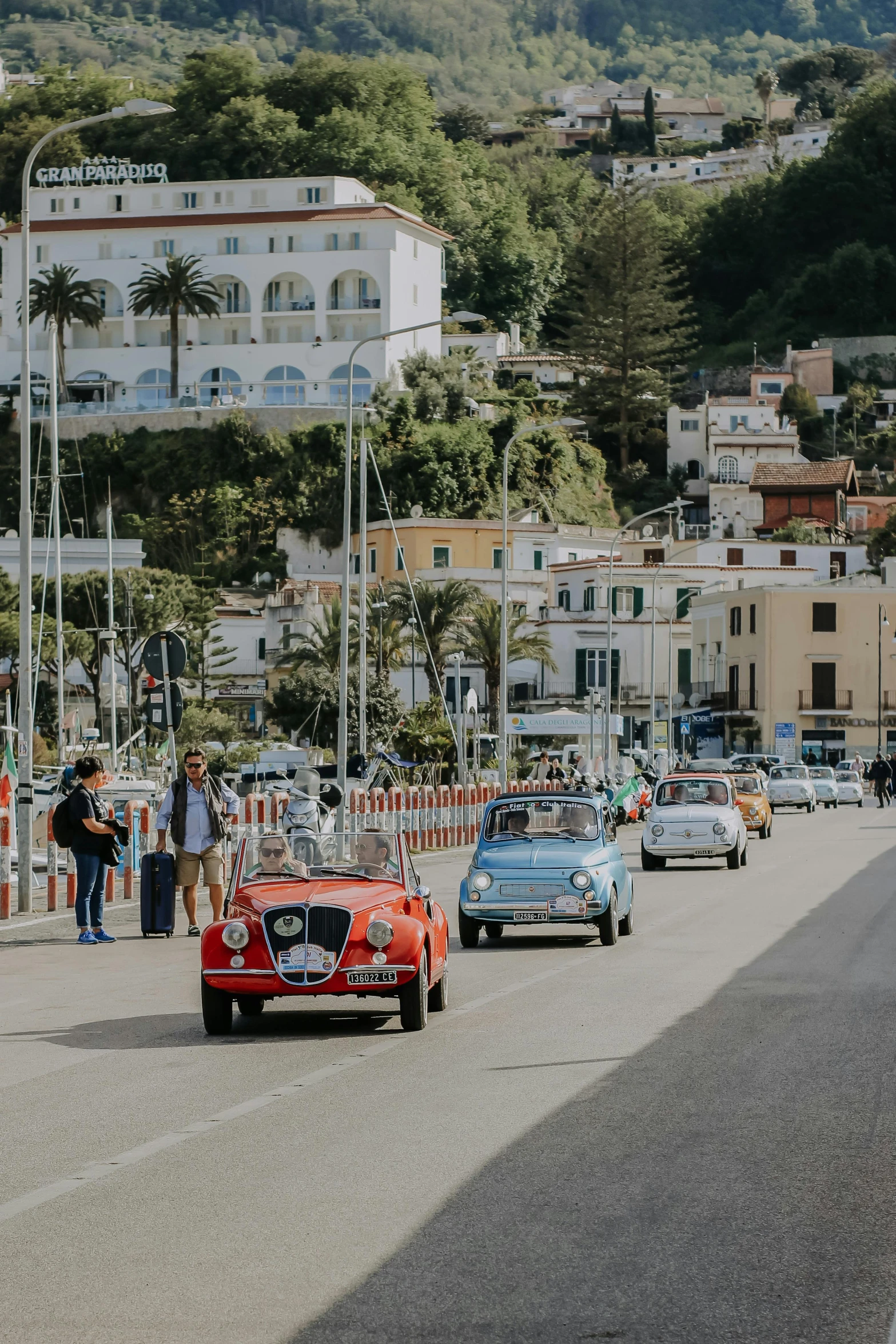 there are cars and people on this street