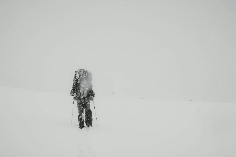 a person walking through the snow with his skis on