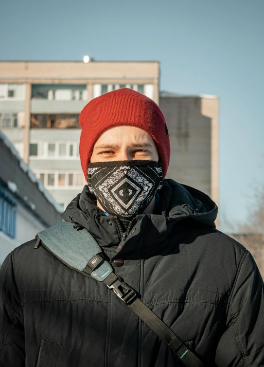 person with face mask over head standing outside