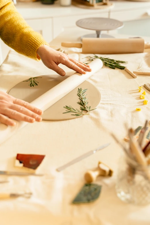 a woman working with various crafting supplies on a table