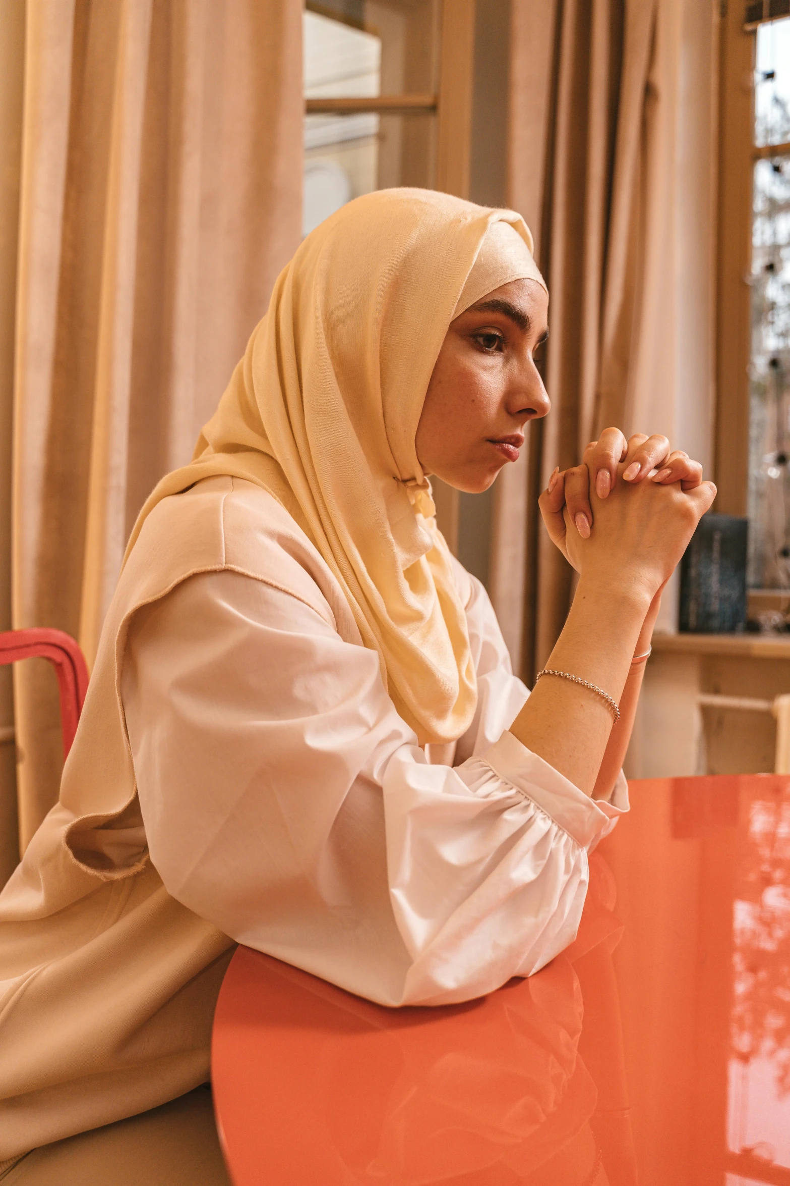 a woman with her arms crossed sits at a table