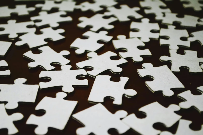 a group of jigsaw pieces of white color on the table