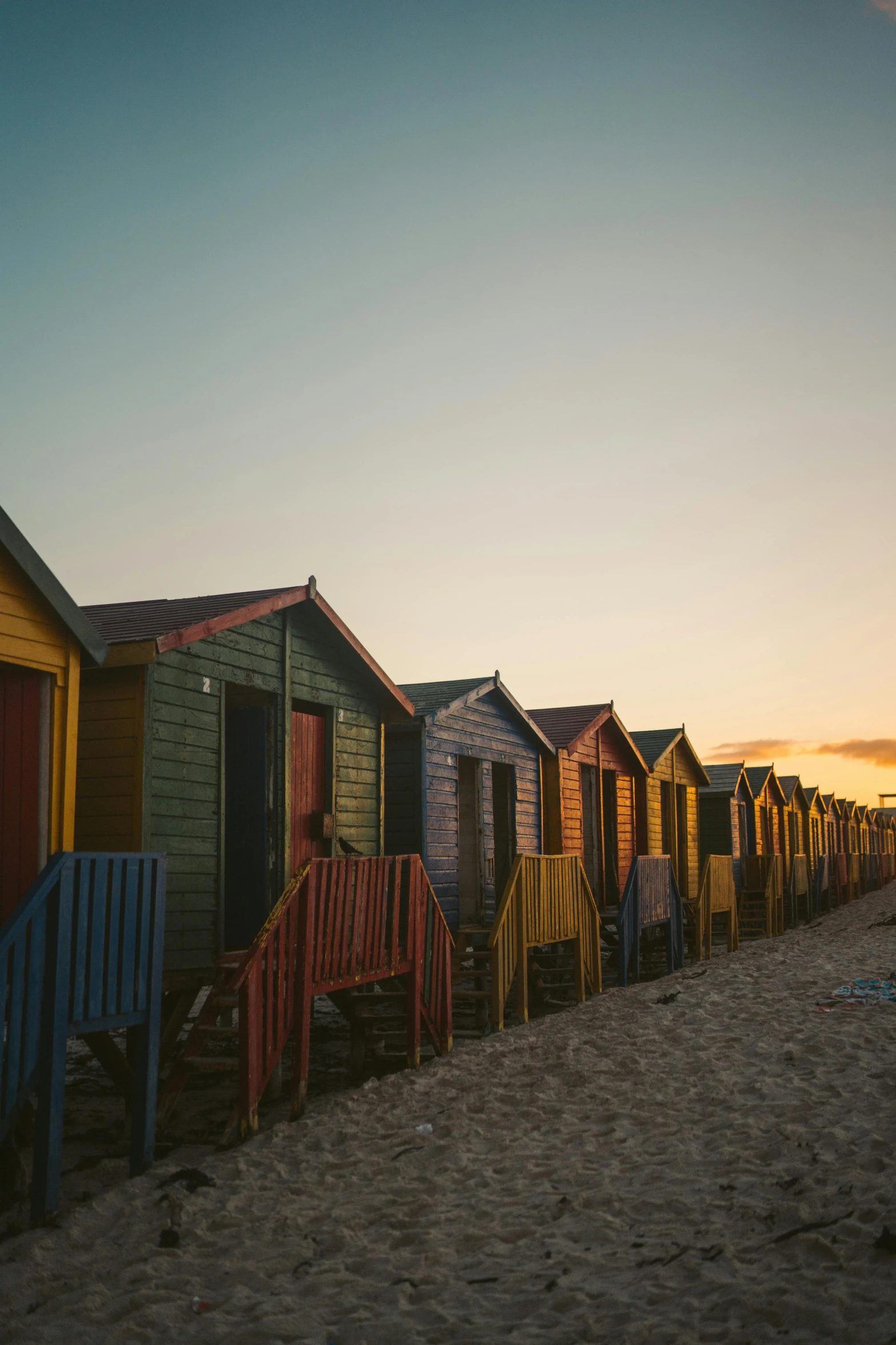 a row of colorful beach huts sitting on the sand