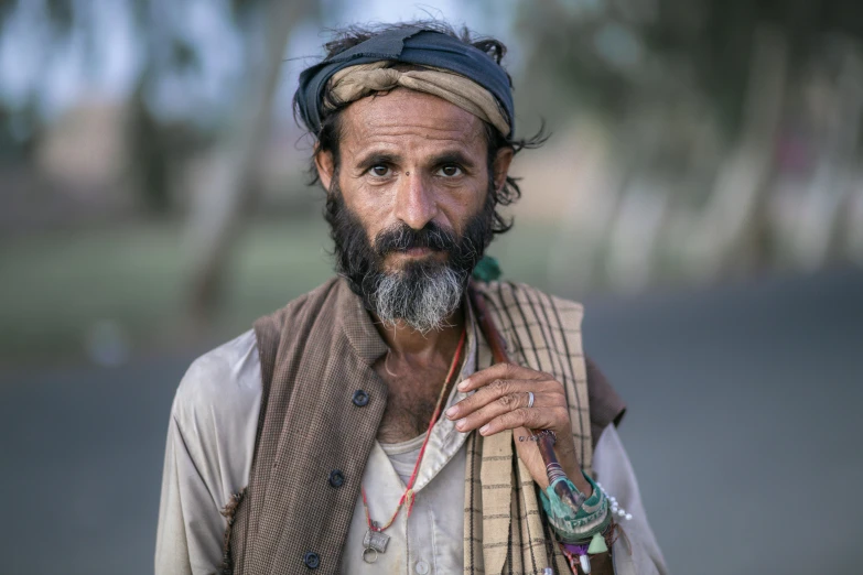 a man with a turban on his head looks off into the distance