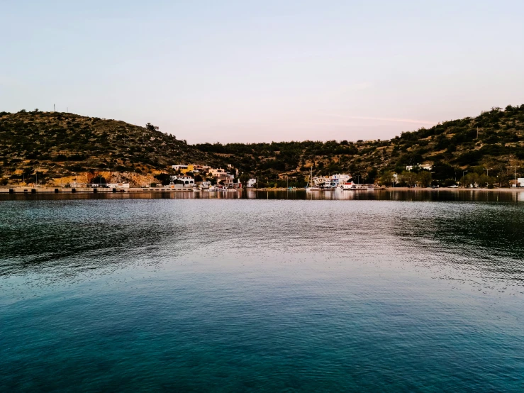 a body of water near some houses in the hills