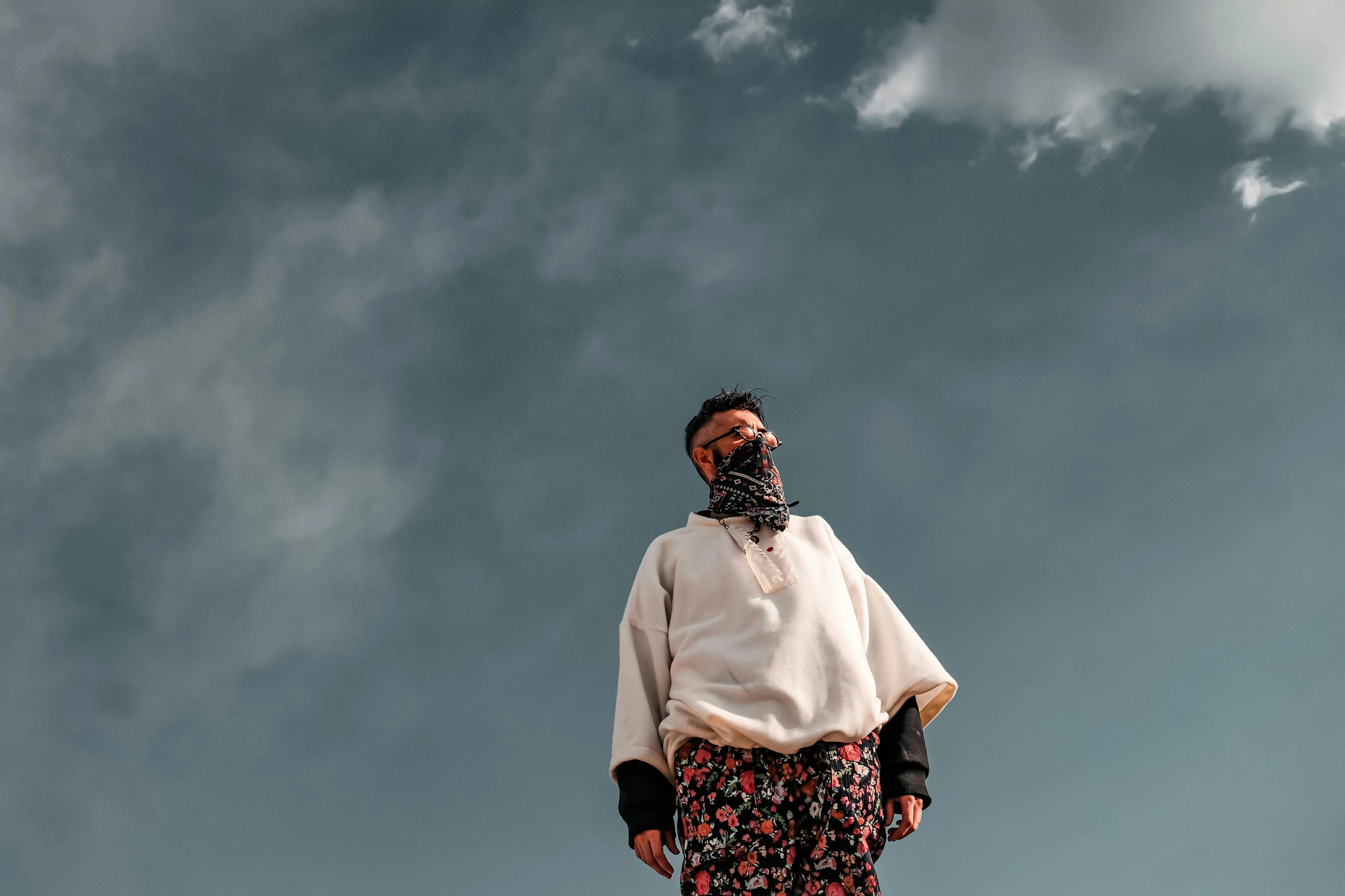 a man standing on top of a roof under a cloudy sky