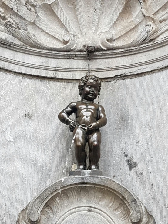 a boy statue with water running through it