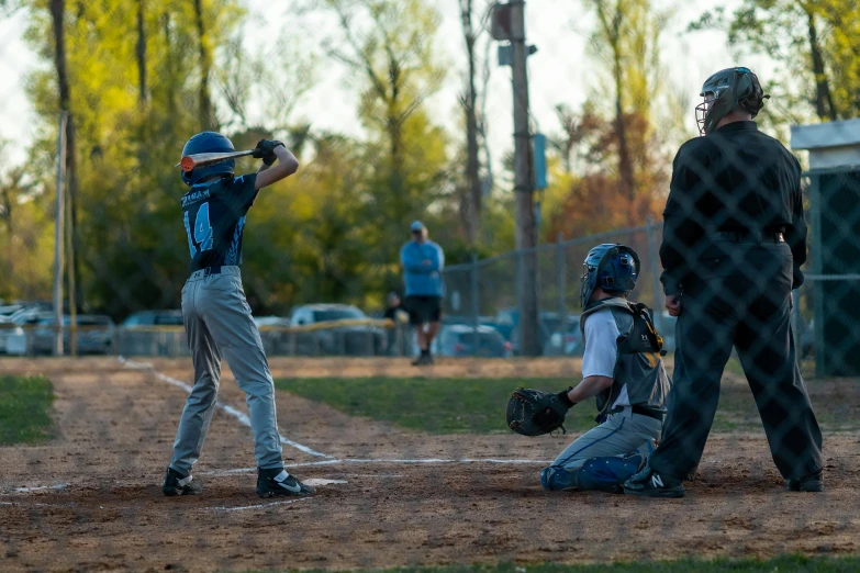 a  in a blue baseball uniform with his glove and mouth covered up