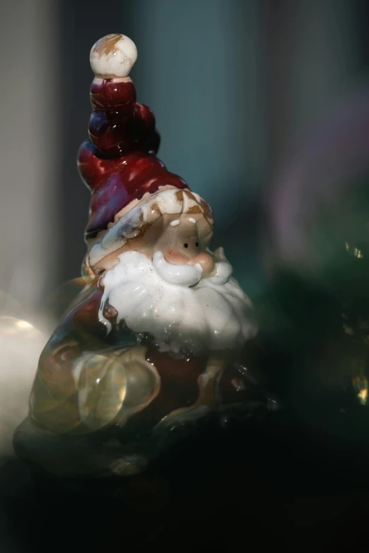 a glass gnome figurine has soing in his mouth