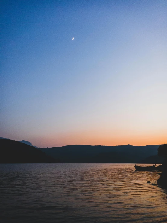 the lone boat is docked on a calm lake