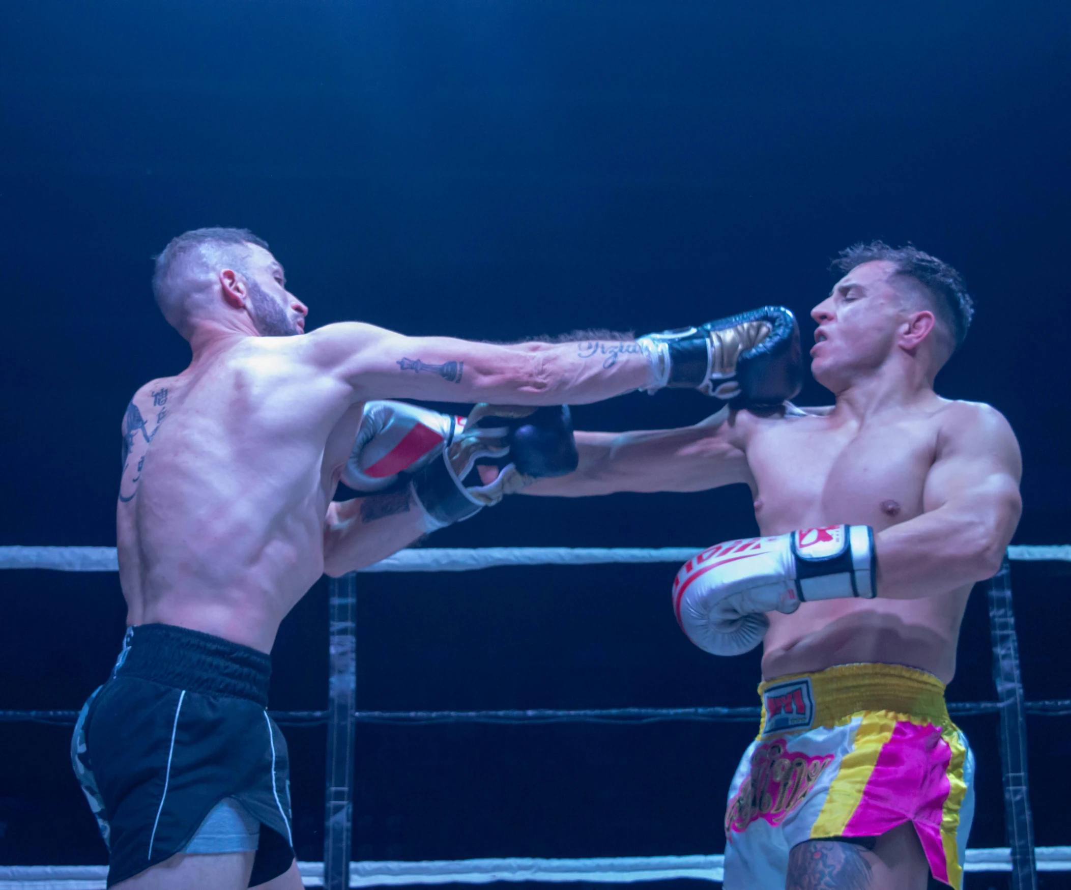 two men standing on top of a ring, one in a boxing ring