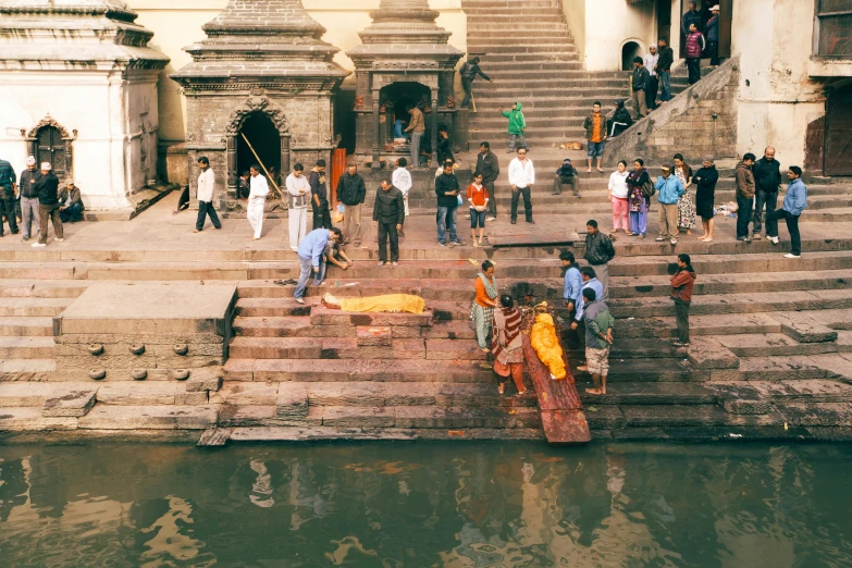 some people are gathered near a stone stairway