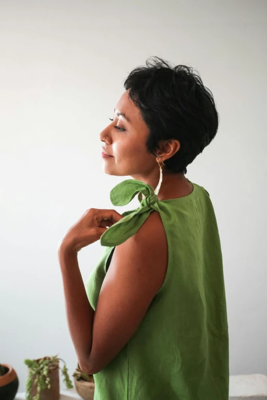 woman wearing a green blouse and a matching necklace