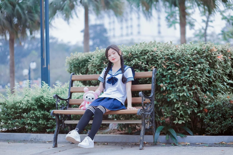 a little girl sitting on top of a wooden bench