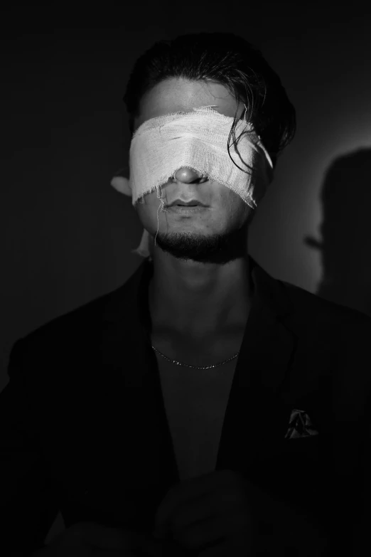 black and white pograph of a man in a blindfold