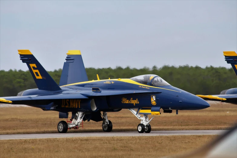 blue fighter planes sit on the runway