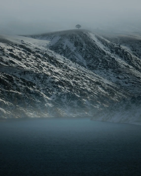 a mountain peak covered in snow with mist covering the mountains