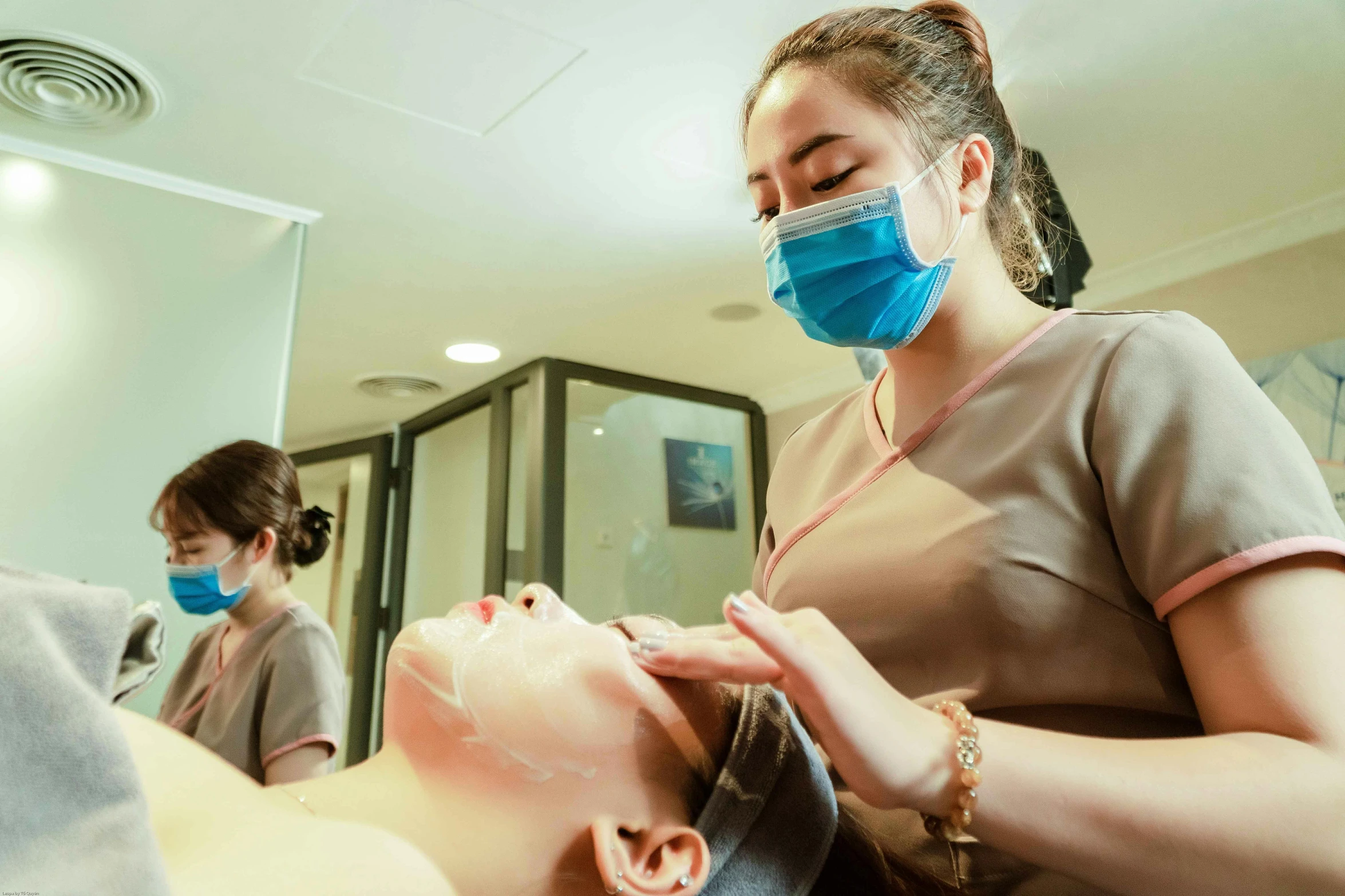 a person is having their hair trimmed before another person takes the scissors