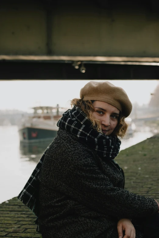 a man is sitting on the sidewalk next to the water