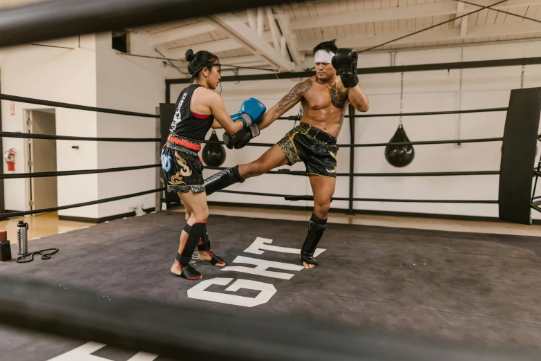 two boxers practicing their kickbox moves inside