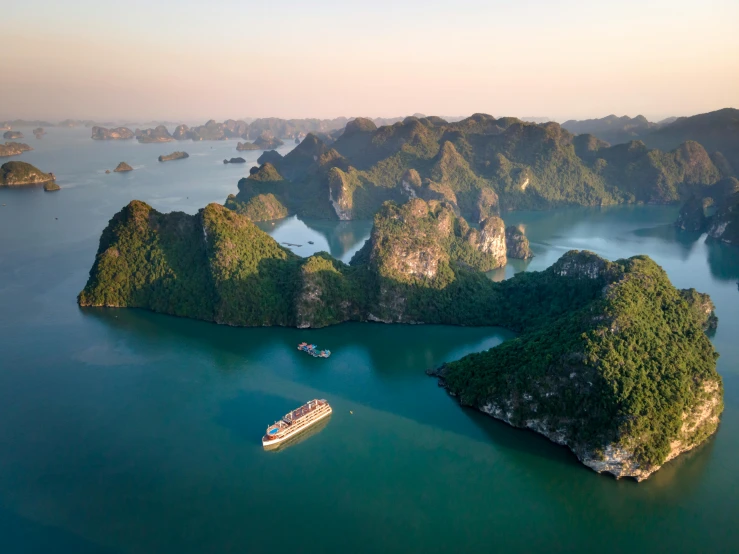 many boats floating on a bay next to some large mountain