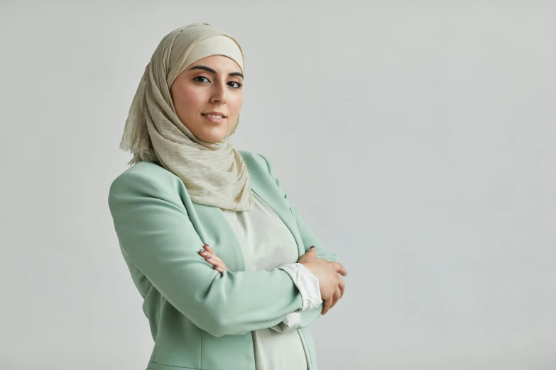 woman standing with her arms crossed and wearing a green jacket