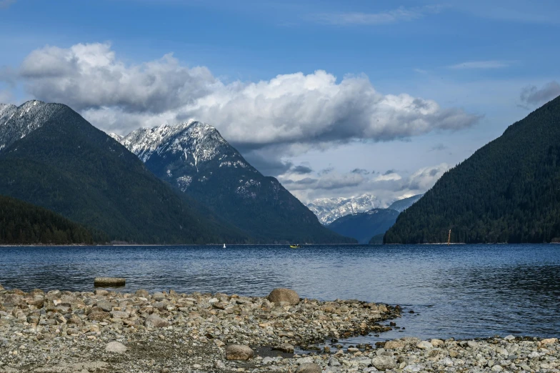 mountain range in background as seen from rocky shoreline