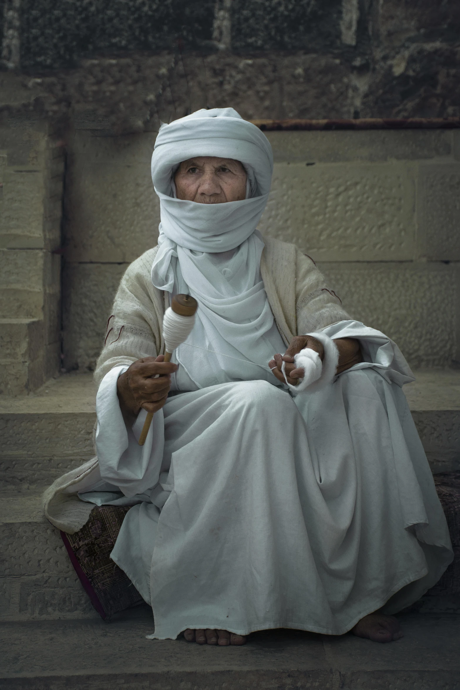 a woman is dressed in white sitting down