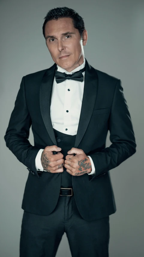 a man in a tuxedo looks up while posing for a portrait