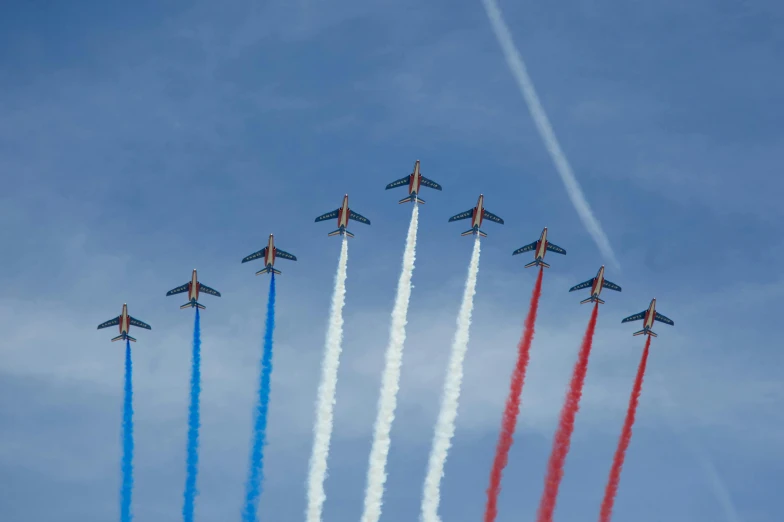 six planes flying side by side in the sky with contrails above