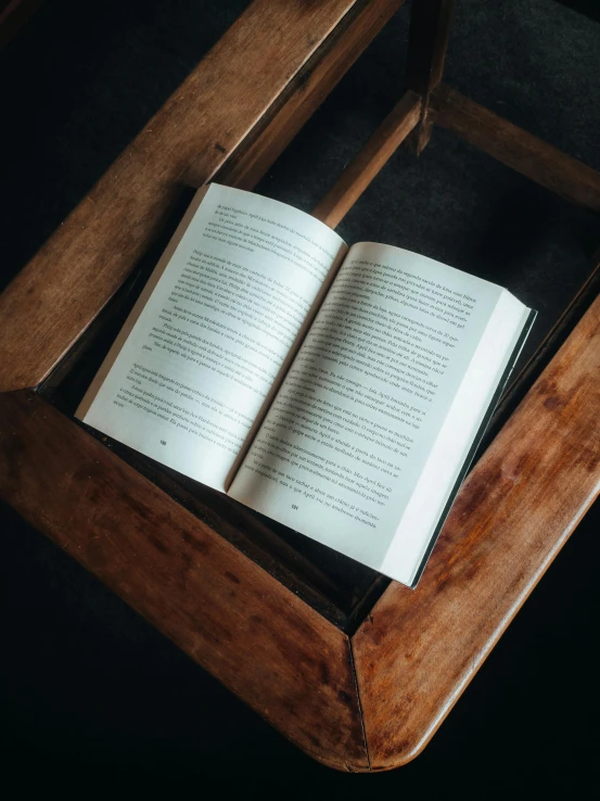 an open book on top of a wooden chair