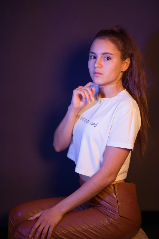 a woman that is sitting on a stool with a toothbrush in her hand