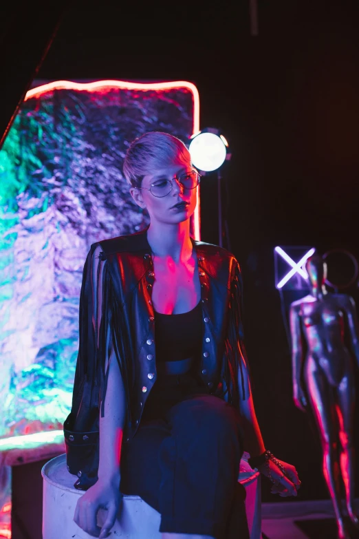 a young woman poses for a portrait in front of a brightly lit backdrop