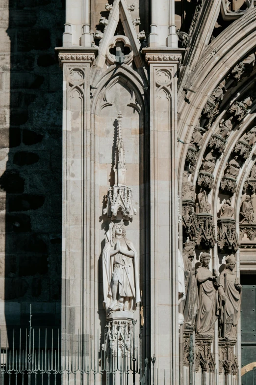 statue is on wall of large building that has ornate decoration