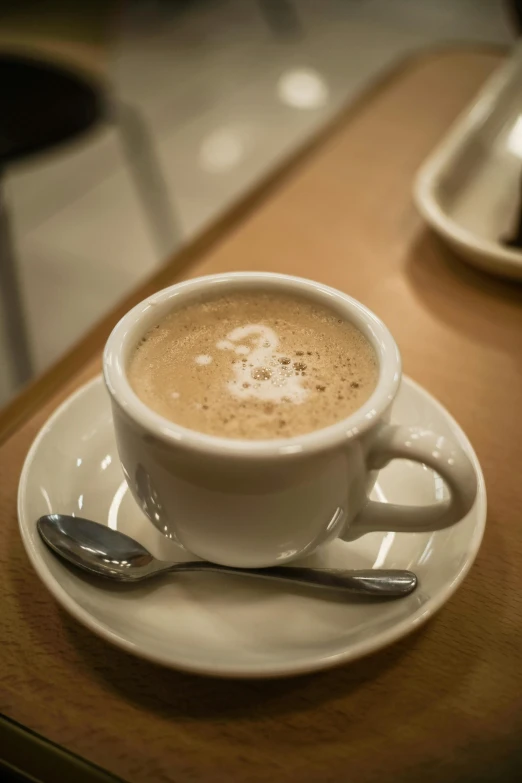 a cup of  chocolate with spoon on a table