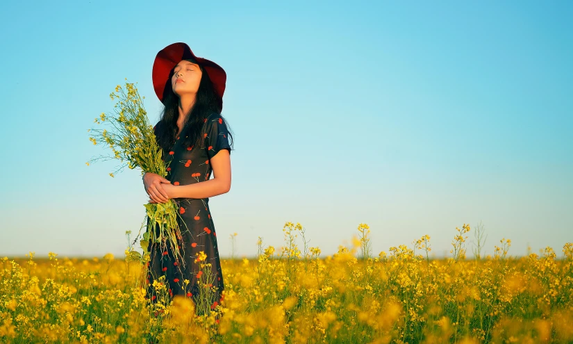 the girl stands in a field with yellow flowers