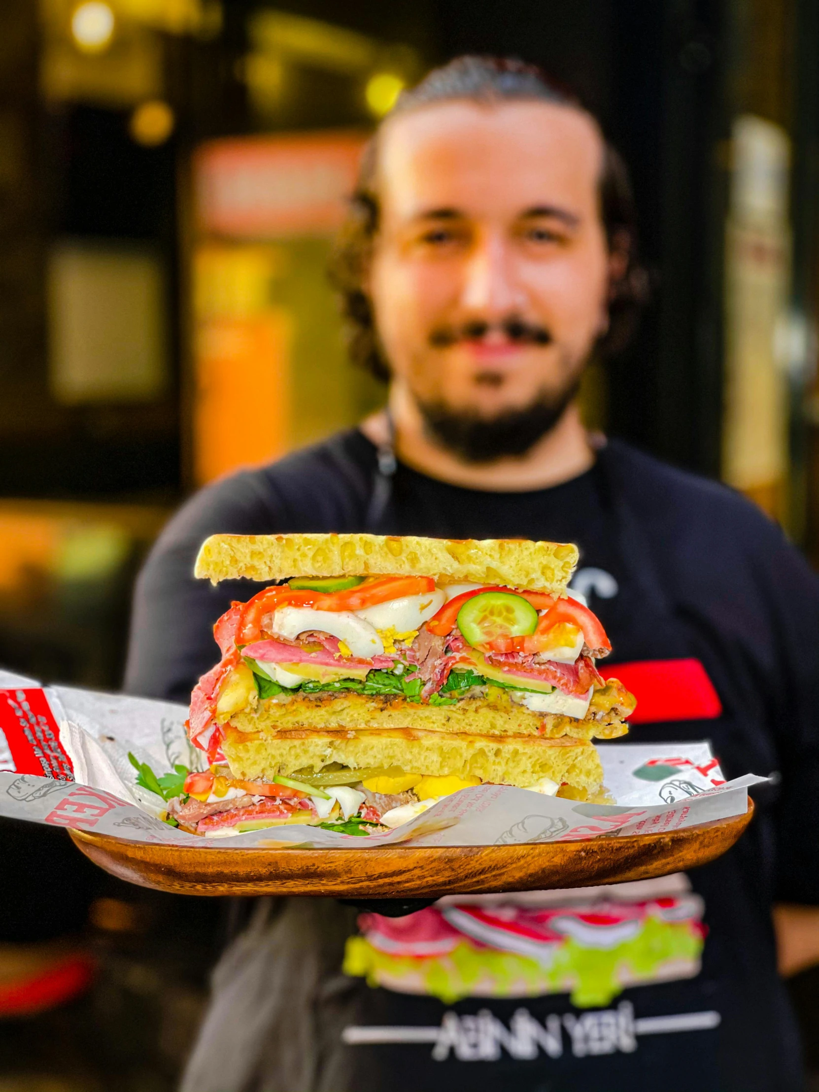 a man holding a sandwich cut in half