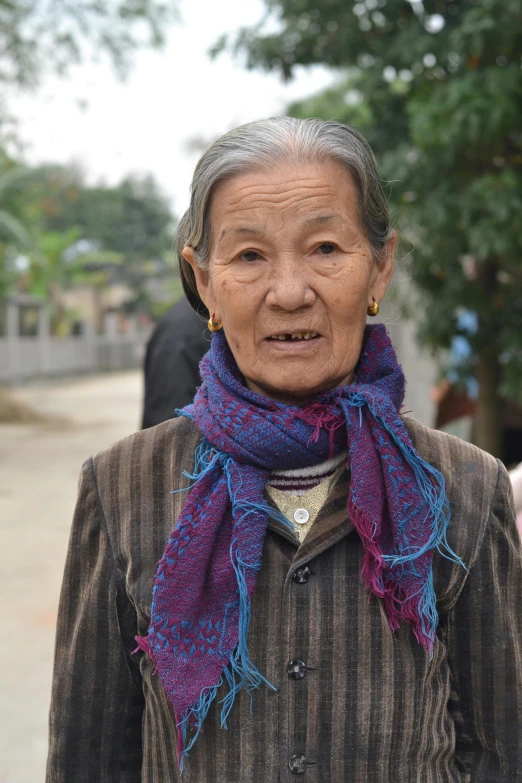 a woman is wearing a purple, blue and black scarf