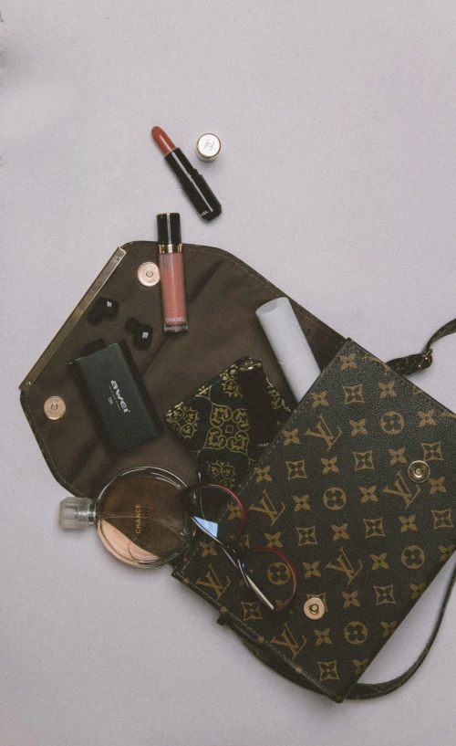 a bag with eyeglasses, lipstick, lipstick and some other items