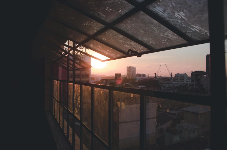 the sun is setting in the city through the windows