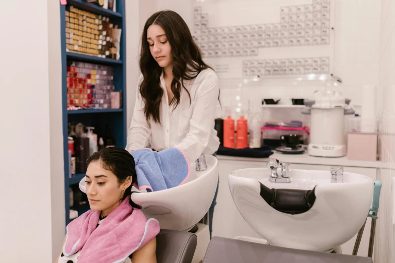 two women are getting their hair washed in a salon