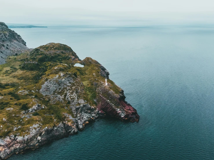 the coastline in an aerial po with the ocean and green hills