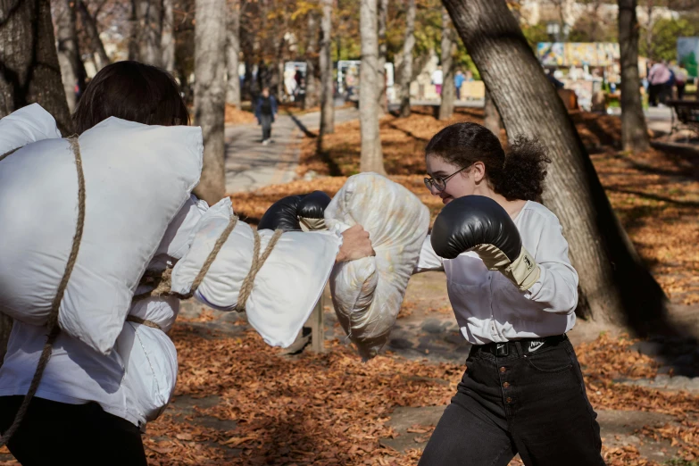 a couple of young ladies in the park boxing