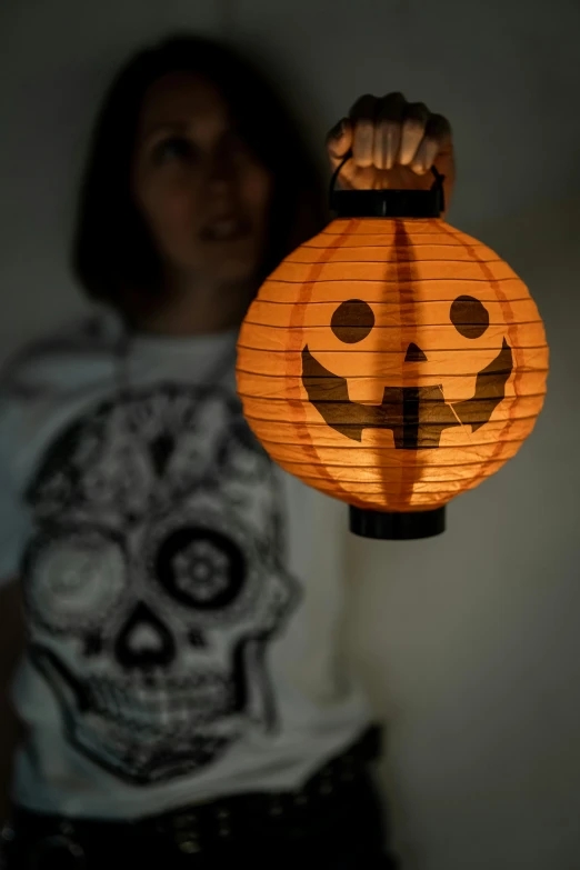 woman standing in front of lighted lantern that has smiley face