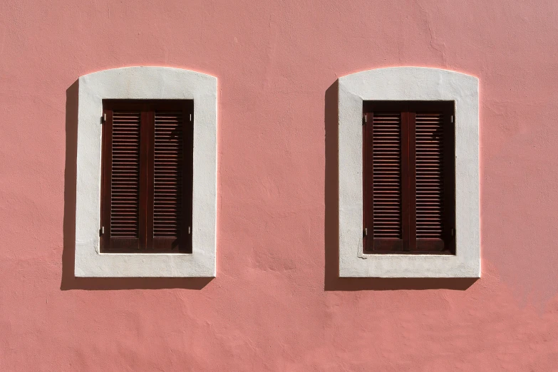 two windows are open on a pink wall