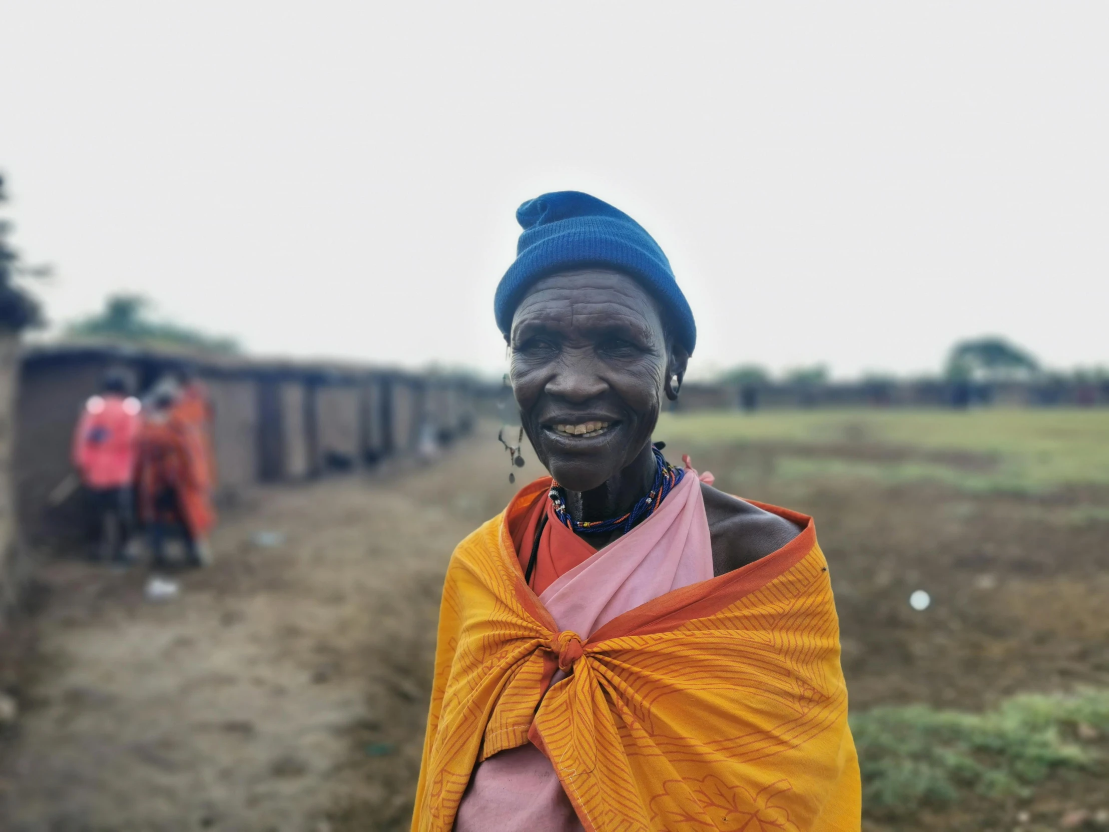 a woman smiles as she stands outside in a rural area