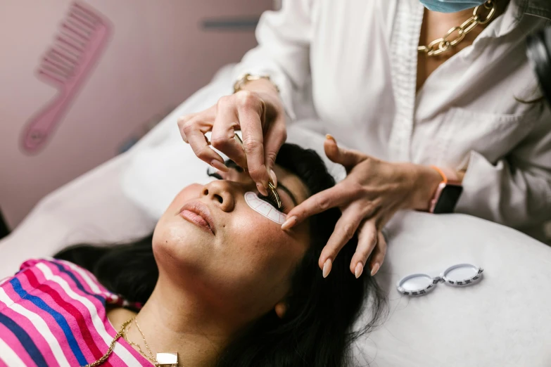 a woman has her nails brushed by a man