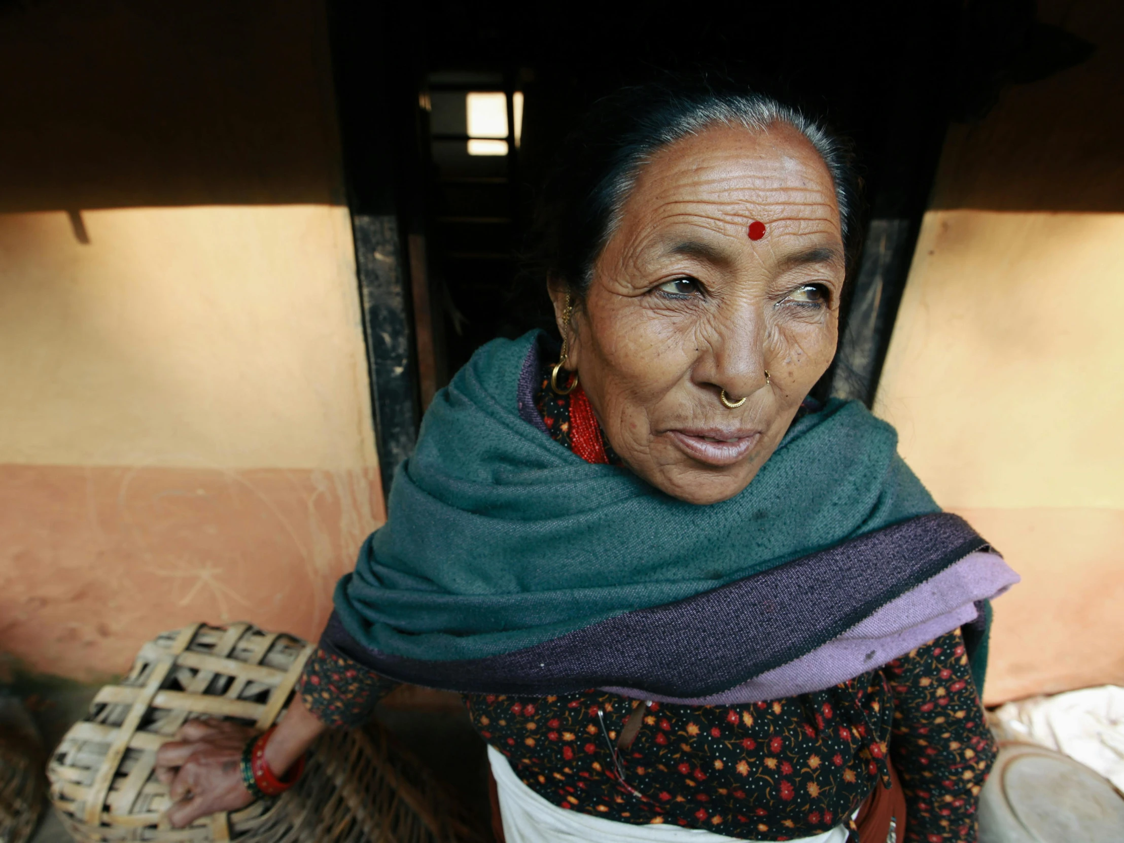 an old woman with jewelry on and in a shawl,