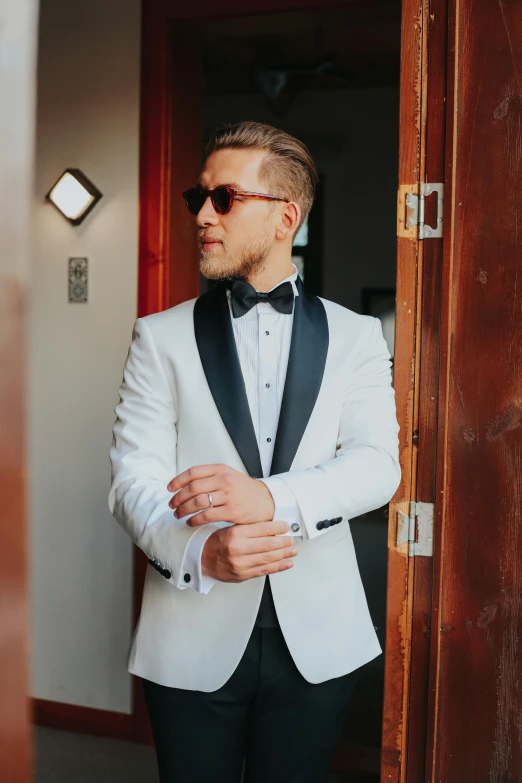 a man wearing sunglasses is standing in a doorway